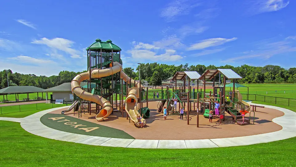 A large children's play park with children playing on it. The Nancy Lane Park is close to Mini Mall Storage