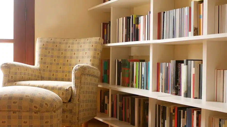 A yellow room with a large bookshelf that has a lot of books on it. 