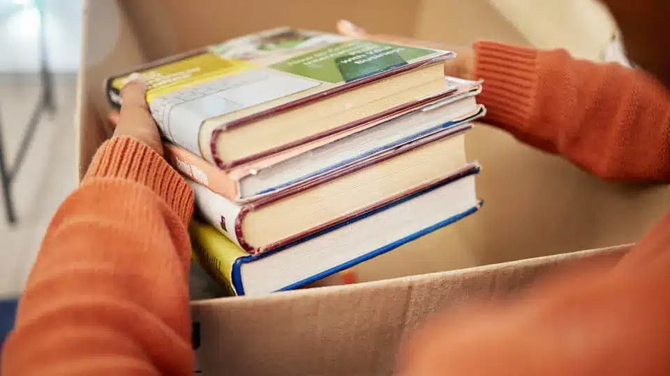 A person packing books into a box to put in their storage unit at Mini Mall Storage