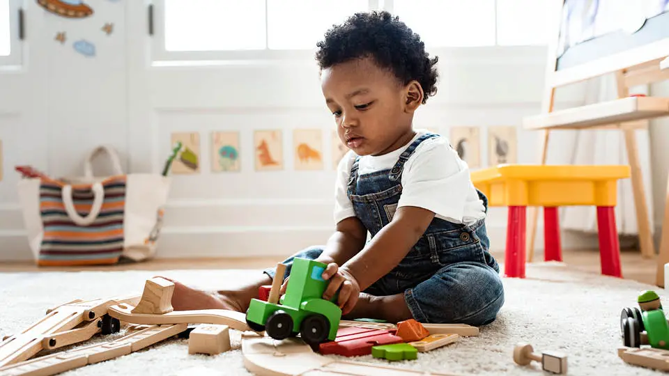 A small child playing with toys in a playroom