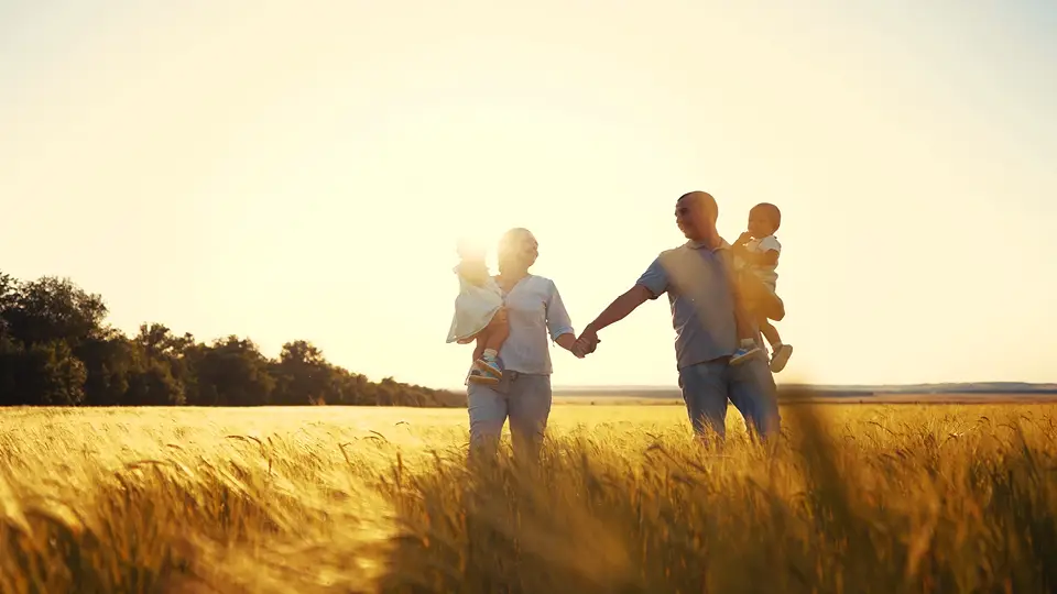 A family holding hands in a field near Saskatoon SK