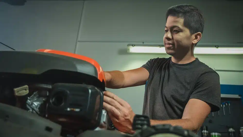 A man preparing his lawn mower for storage