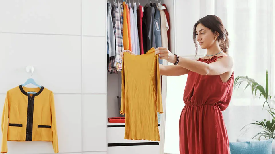 Woman sorting clothes and deciding to put extras in a storage unit